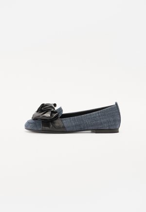 Blå denim flad sko med sort læder sløjfedetalje på tåen og sort lædertrim på flad sål, vist i sidevisning.