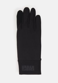 Mănuși negre dintr-un material elastic, cu un finisaj neted, având un accent cu logo și o zonă texturată pentru prindere pe degetul mare.