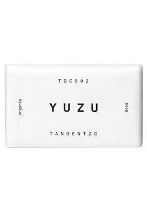 Rechteckiger weißer Seifenblock mit der Aufschrift "YUZU" sowie den schwarzen Texten "TGC502", "organic", "soap" und der Marke "TANGENTGC".