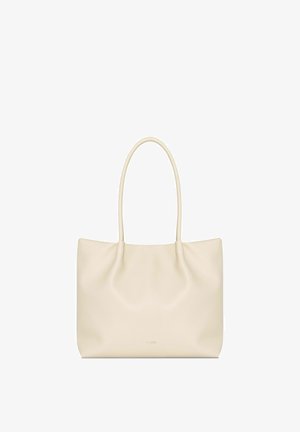 Kremowa torba na ramię wykonana z miękkiej skóry o gładkiej teksturze, lekko marszczonym wzorze i dwoma okrągłymi uchwytami. Minimalistyczne logo z przodu.