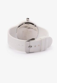 White silicone strap watch with a round silver-tone case and a textured back. Features a metal clasp and adjustable holes on the band.