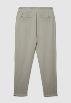 Pantalon de survêtement gris clair en tissu doux, avec une taille élastique, deux poches arrière et des bords resserrés aux chevilles.