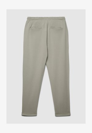 Pantalon de survêtement gris clair en tissu doux, avec une taille élastique, deux poches arrière et des bords resserrés aux chevilles.