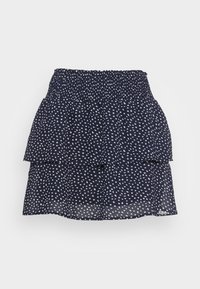 Navy tiered skirt made from a lightweight, sheer fabric featuring a scattered white heart pattern and an elastic waistband.