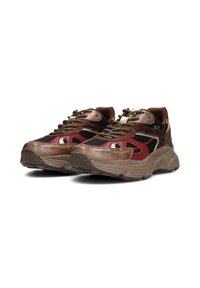 Sneakers chunky che presentano un mix di materiali marrone scuro, rosso e nero. Pannelli in rete testurizzati, dettagli metallici e lacci decorati.
