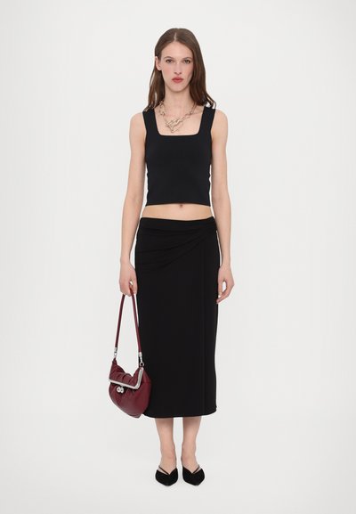 Black cropped top with square neckline, paired with a black draped midi skirt. Accessories include a burgundy bag with silver hardware.
