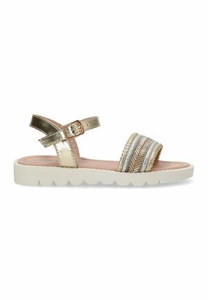 Sandalias metálicas doradas con una correa ajustable en el tobillo, dos bandas decorativas anchas con texturas mixtas y una suela blanca con forma de ola.