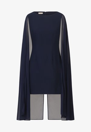 Navyblauwe jurk met een gestructureerde silhouet, voorzien van doorschijnende cape-mouwen en een contrasterend lichtgrijze paneel aan de zoom. Rits aan de achterkant.