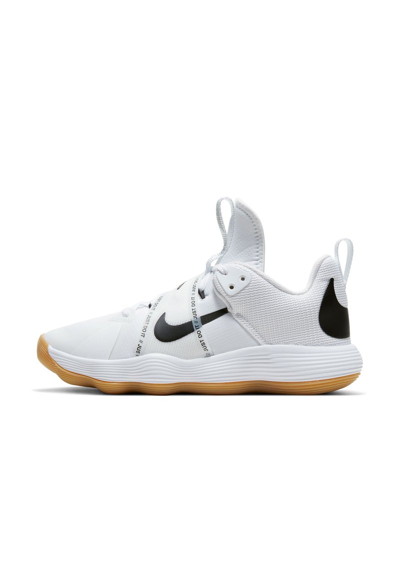 Baskets de sport blanches avec un dessus texturé, logo Nike noir et semelle en caoutchouc naturel ; présentent un laçage proéminent et une languette de traction.