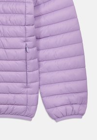 Μανίκι μπουφάν με επένδυση από λεβάντα και εμπρόσθιο τμήμα με οριζόντιο ράψιμο και ελαστικό μανσέτα, που δείχνει μερικώς φερμουάρ πλαϊνής τσέπης.