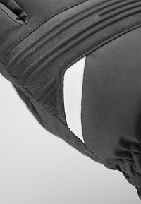 Gant isolant noir avec une texture matelassée, comportant une bande d'accent blanc et des motifs striés au niveau du poignet pour une prise en main améliorée.