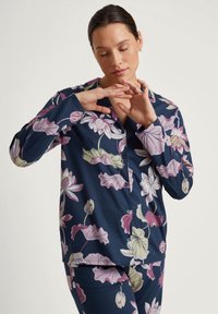 Marineblauw bloemenpyjamastel met grote rozen en groene bloemen, met lange mouwen en een knoopsluiting aan de voorkant. Gemaakt van zachte, comfortabele stof.