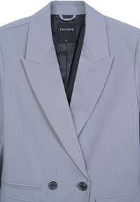 Blazer doppiopetto grigio chiaro con ampi risvolti, due bottoni neri, tasche a filetto frontali e un'etichetta interna nera con la scritta "CALLIOPE S."
