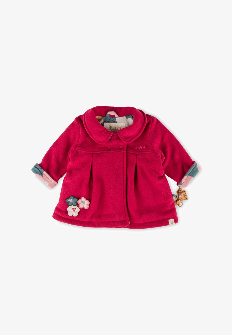 Giacca in pile rossa con colletto arrotondato, pieghe, applicazioni floreali e maniche a contrasto. Include un accento hardware giocoso.