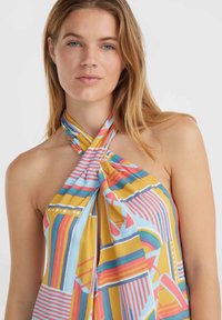 Farebný halter top s geometrickými vzormi v žltej, modrej, červenej a ružovej farbe. Vyrobený z mäkkej látky s dizajnom prekríženého výstrihu.