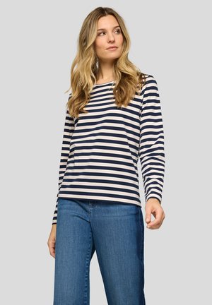 Langärmliges gestreiftes Hemd in Marineblau und Creme, mit lockerem Schnitt und weichem Stoff. Kombiniert mit hellblauen Jeans.