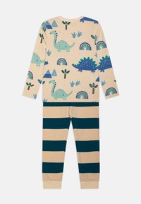 Set de pijama de dos piezas que incluye una parte superior crema con estampados coloridos de dinosaurios y mangas largas, acompañada de pantalones rayados en azul marino y crema.
