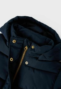 Navy puffer jacket with a hood, featuring a gold zipper and snap buttons, padded texture, and layered fabric detailing.