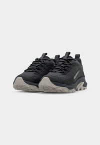 Black hiking shoes with a textured upper, reflective accents, thick gray outsole, and a reinforced toe cap for durability and traction.
