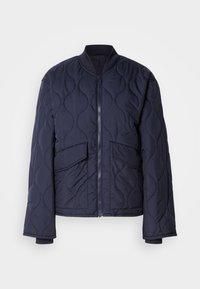 Marineblå, quilted bomberjakke med ribbestrikkede mansjetter, høy krage og to frontlommer. Har en glatt tekstur og glidelås-lukking.