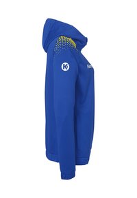 Blauwe sportjack met capuchon, voorzien van een gele geometrische patroon op de schouder. Soepele textuur, ritssluiting aan de voorkant en elastische manchetten.