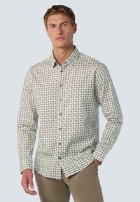 Witte overhemd met een groen en paars geometrisch patroon. Kenmerkt zich door een klassieke kraag en lange mouwen, gecombineerd met kaki broek.