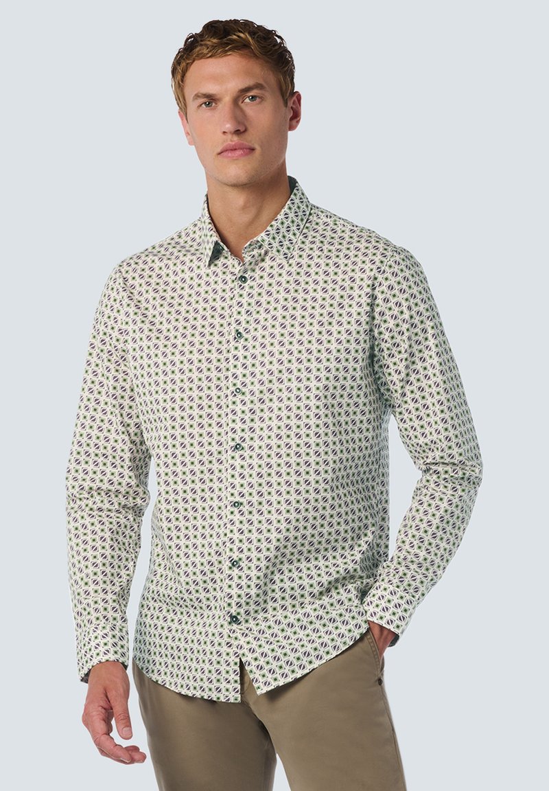Witte overhemd met een groen en paars geometrisch patroon. Kenmerkt zich door een klassieke kraag en lange mouwen, gecombineerd met kaki broek.