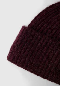 Berretto in maglia bordeaux con una trama a costine. Realizzato in materiale morbido, presenta un design con risvolto per maggiore calore e comfort.