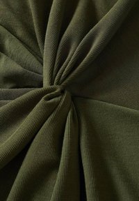 Tissu côtelé vert olive avec un motif torsadé, présentant une texture lisse et un éclat subtil, rassemblé au centre en plis doux.