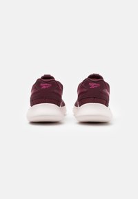 Baskets Reebok en bourgogne avec des accents roses, présentant une tige en maille, une semelle blanche rembourrée et une languette au talon.