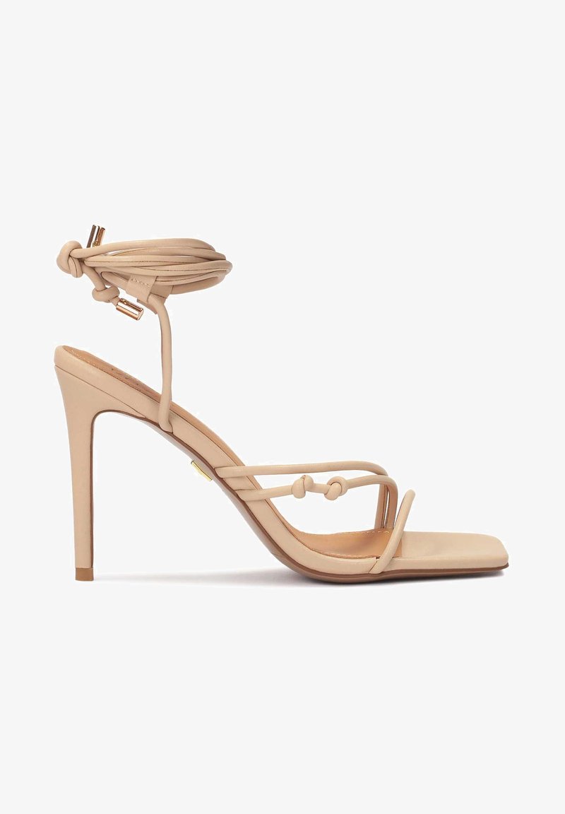 Nude högklackade sandaler med fyrkantig tå, tunna remmar och ankelwrap. Har knutna detaljer och en slät lädertextur.
