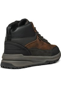 Stivale da trekking mid-top con una combinazione di suede marrone e pelle nera, pannelli testurizzati, dettagli marroni e una suola in gomma grigia spessa con trazione.