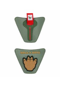 Toppa in pelle verde di forma triangolare con motivo di artiglio rialzato e texture marrone simile al legno; presenta una linguetta rossa e lettere in grassetto.