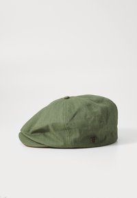 Casquette plate en tissu vert à finition texturée, dotée d'une petite étiquette logo et d'une forme arrondie. Visière incurvée avec un bord surpiqué.