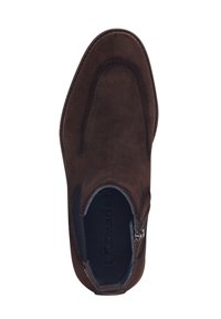 Chaussure slip-on en suede marron avec une texture lisse, dotée d'une fermeture éclair sur le côté et d'un design à bout arrondi. Rembourrage intérieur visible.