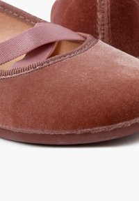 Ballerine rosa in velluto con punta arrotondata, fascia elastica e texture liscia. La suola è piatta e flessibile, con dettagli di cucitura delicati.