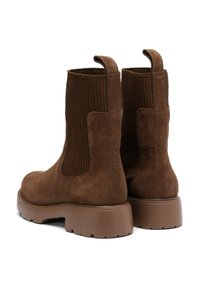 Hnědé semišové kotníkové boty s žebrovanými elastickými bočními panely a pevnými hnědými gumovými podrážkami. Plochý podpatek s okrouhlými poutky pro snadné obouvání.