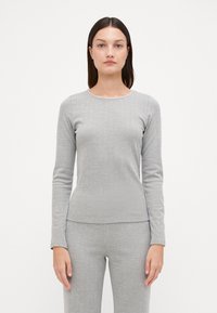 T-shirt à manches longues gris clair en tissu texturé avec un motif à côtes subtil et un col rond, présentant une coupe décontractée.