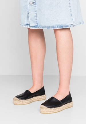 Czarne skórzane espadryle z zaokrąglonym noskiem i podeszwą na platformie z plecionego juty. Cholewka ma gładkie wykończenie, kontrastujące z fakturowaną podeszwą.