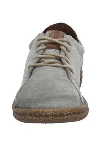 Šedé semišové šněrovací boty s kulatou špičkou, hnědé kožené akcenty poblíž šněrování a texturovaná hnědá gumová podrážka.