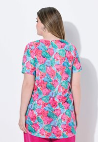 Top a maniche corte con un vivace motivo floreale in tonalità di rosa, verde e blu, dotato di una vestibilità ampia e di un collo rotondo.