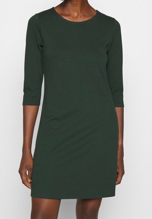 Vestito verde scuro, lungo fino al ginocchio, realizzato in un tessuto morbido. Presenta un collo tondo e maniche a tre quarti, con una silhouette aderente.