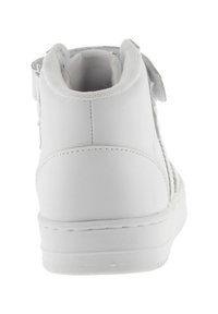 Sneaker alta bianca con una superficie sintetica liscia, cinturino con velcro, collo imbottito e suola piatta in gomma.