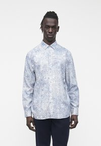 Šviesiai mėlyna marškiniai su gėlėmis ir abstrakčiais raštais, ilgomis rankovėmis, smailėjančiais atlapais ir priekinėmis sagomis. Pagaminti iš glotnaus audinio.