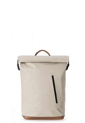 Zaino roll-top in materiale beige chiaro con base in pelle marrone, dotato di una tasca con zip laterale e di un manico in pelle sulla parte superiore.
