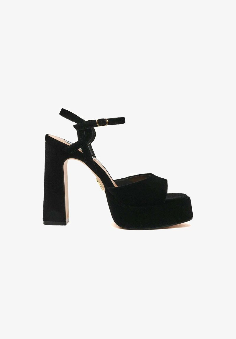 Sandali platform neri con una texture vellutata, cinturino alla caviglia e tacco a blocco. Design con punta arrotondata e dettaglio minimo in oro.