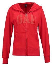 Czerwona bluza z kapturem na zamek błyskawiczny, z przednią kieszenią, z kapturem oraz logo "GAP" w jaśniejszym kolorze na klatce piersiowej. Miękka, strukturalna tkanina.