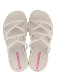 Białe sandały z teksturowaną podeszwą, z crossoverowym wzorem paska. Paski wykonane są z elastycznego materiału o gładkim wykończeniu.