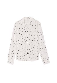 Chemise boutonnée à manches longues, blanche avec des motifs de cœurs noirs. Comprend un col et des poignets boutonnés. Tissu léger avec une texture lisse.