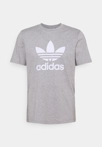 Šedé bavlněné tričko s krátkými rukávy, na kterém je bílý logo Adidas a tři vodorovné pruhy pod květinovým motivem.